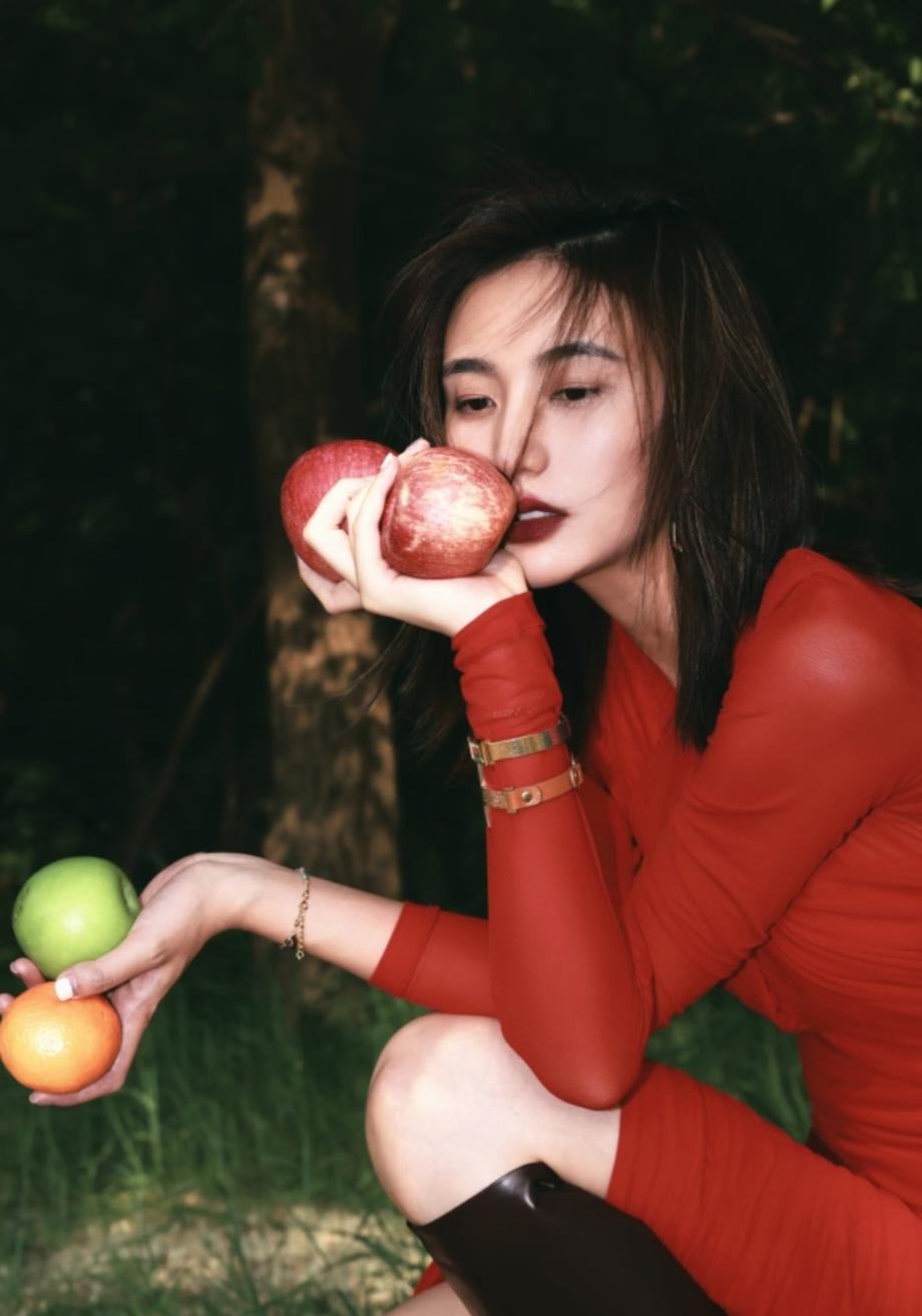 李亚鹏前妻海哈金喜晒出一组照片，
红色裙子配长靴，
躺在草地上，
嗅着手中苹果的
