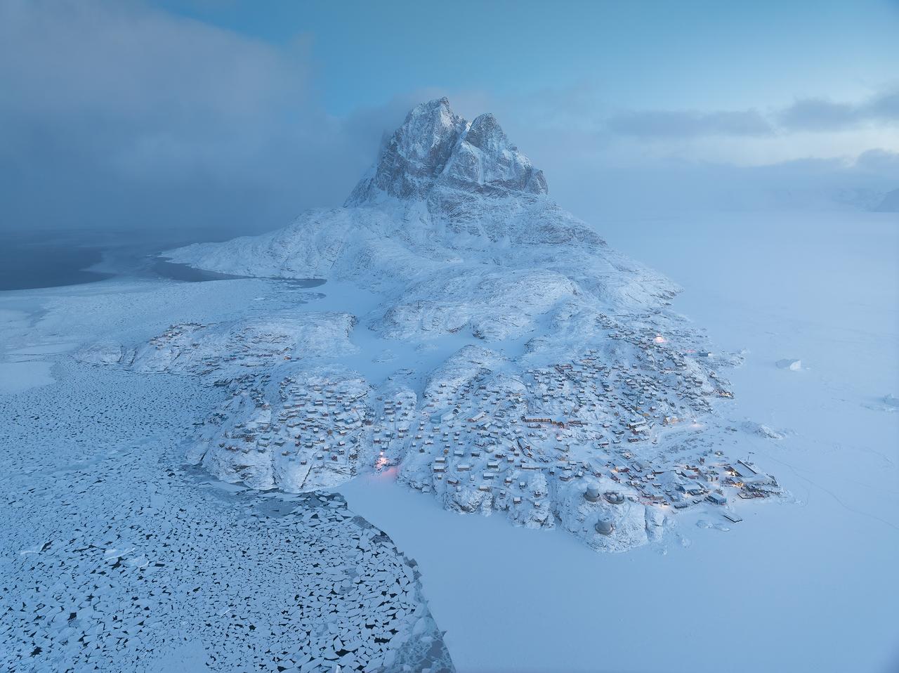 冬季的乌玛纳克，是把北极的浪漫焊在地图上的地方。三座锥形雪峰刺破寒雾，在蓝调时刻