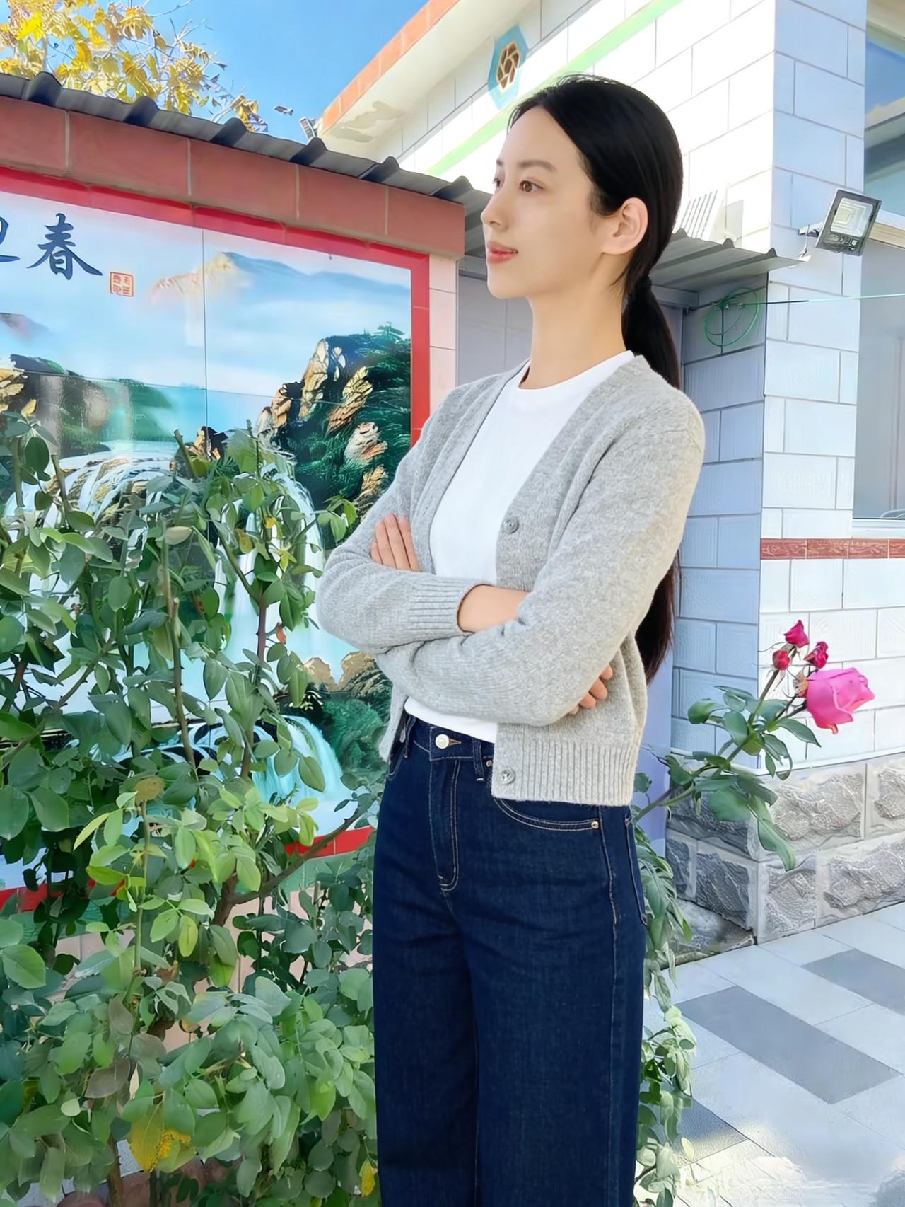 浅灰开衫衬素容，庭院花木自葱茏。
抱臂凝望云天外，一缕清思寄远峰。