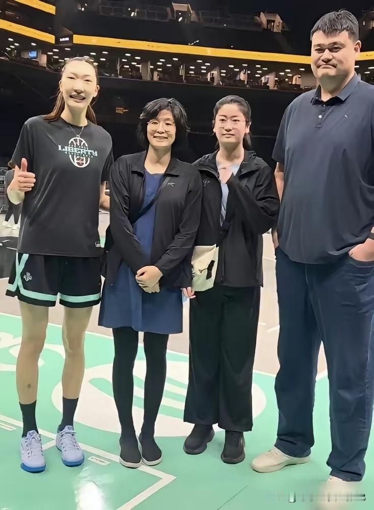 姚明的女儿姚沁蕾跟爸爸一起去看比赛，她个子高挑，站在爸爸的身边没有矮多少，长相落