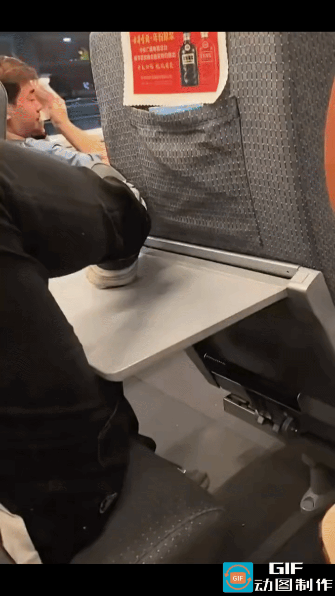 高铁上，男子直接把穿着鞋子的脚搭在小桌板上，左脚搭累了又换上右脚，完全不顾公共卫
