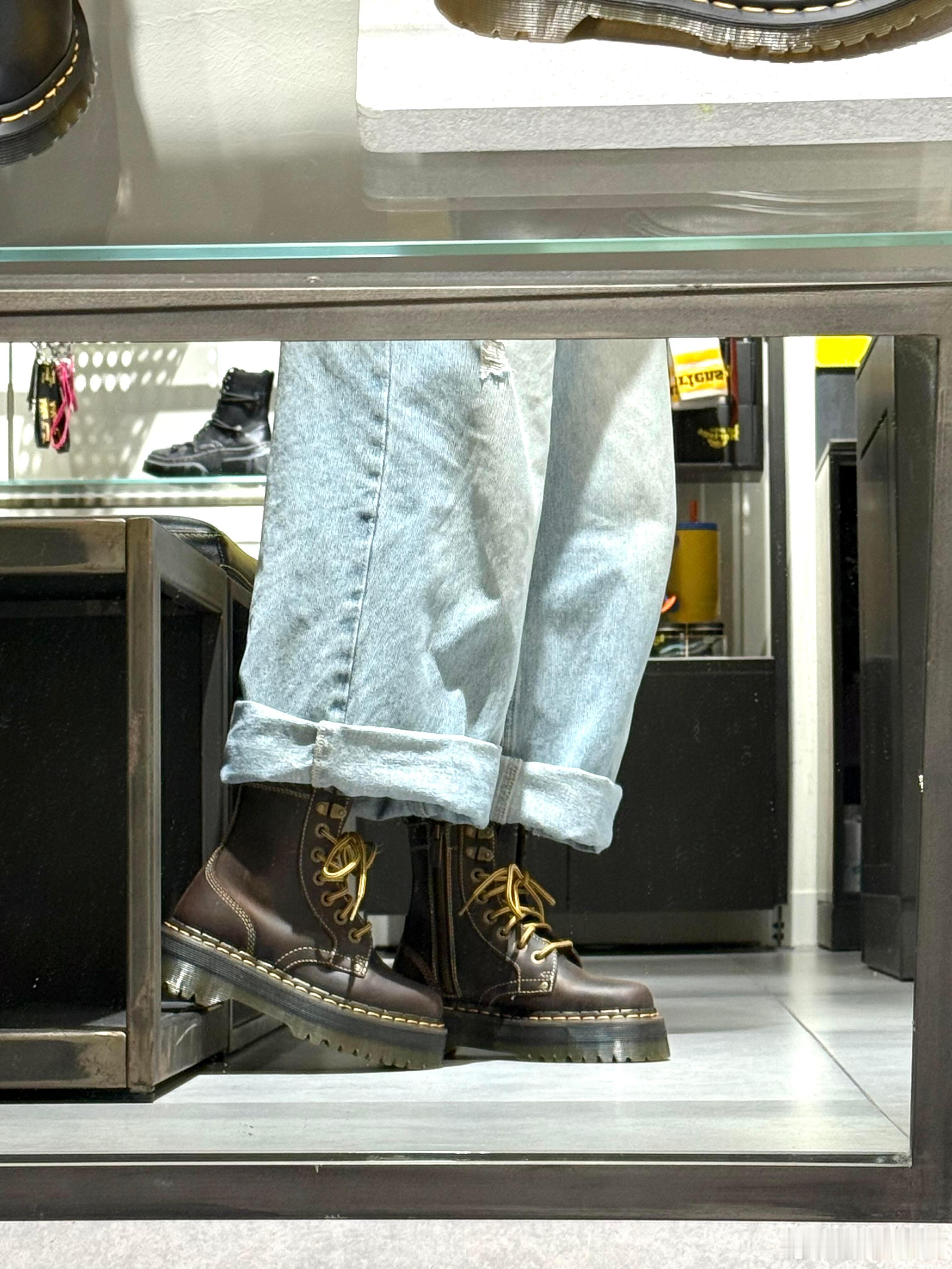 这双深棕色马丁靴采用质感饱满的优质皮革制成，鞋带孔与鞋带均选用闪耀的金色系，为经