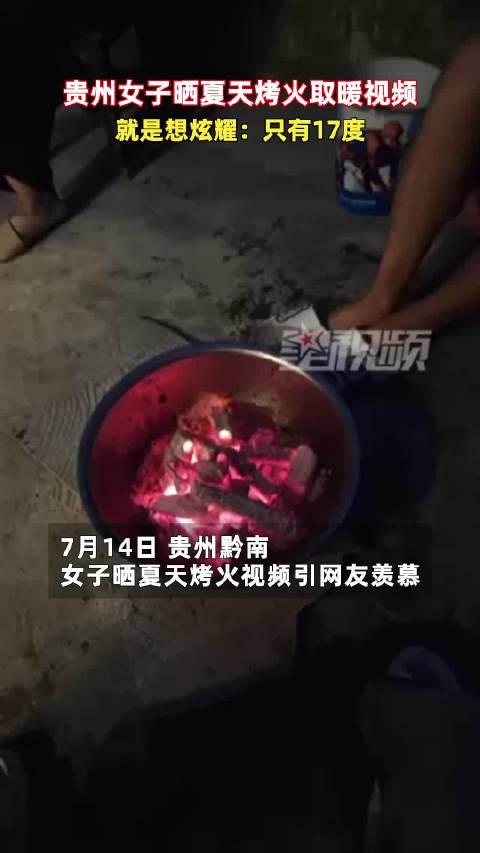 【女子夏天烤火炫耀只有17度，穿短衣短裤冷到受不了】7月14日，贵州黔南。女子晒