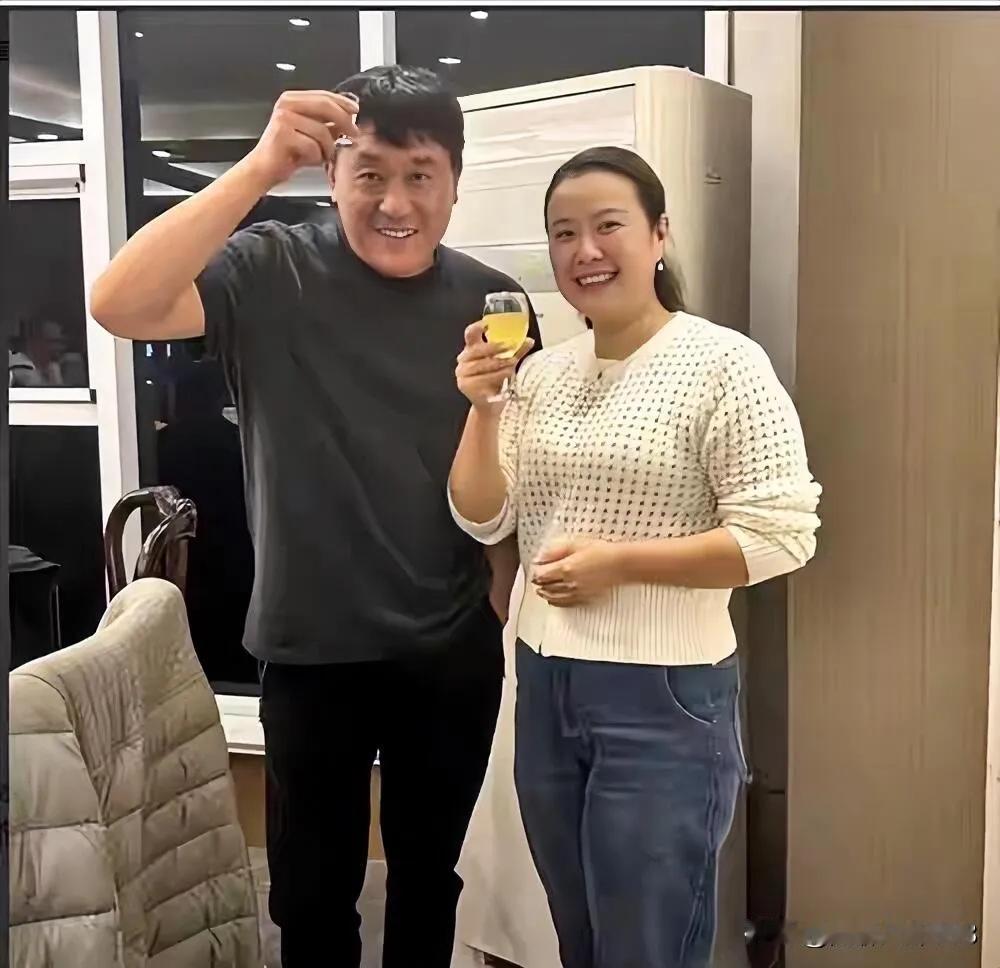 演员何冰带着老婆李海洋一起外出聚餐，何冰拿着一小杯酒，何冰是话剧与影视双栖的实力