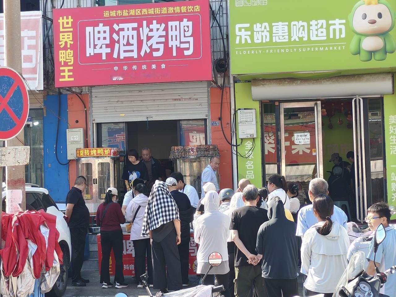 哇噻，在运城盐湖西街口，一家啤酒烤鸭门前排着长长的队伍，这都是等着买烤鸭。

这