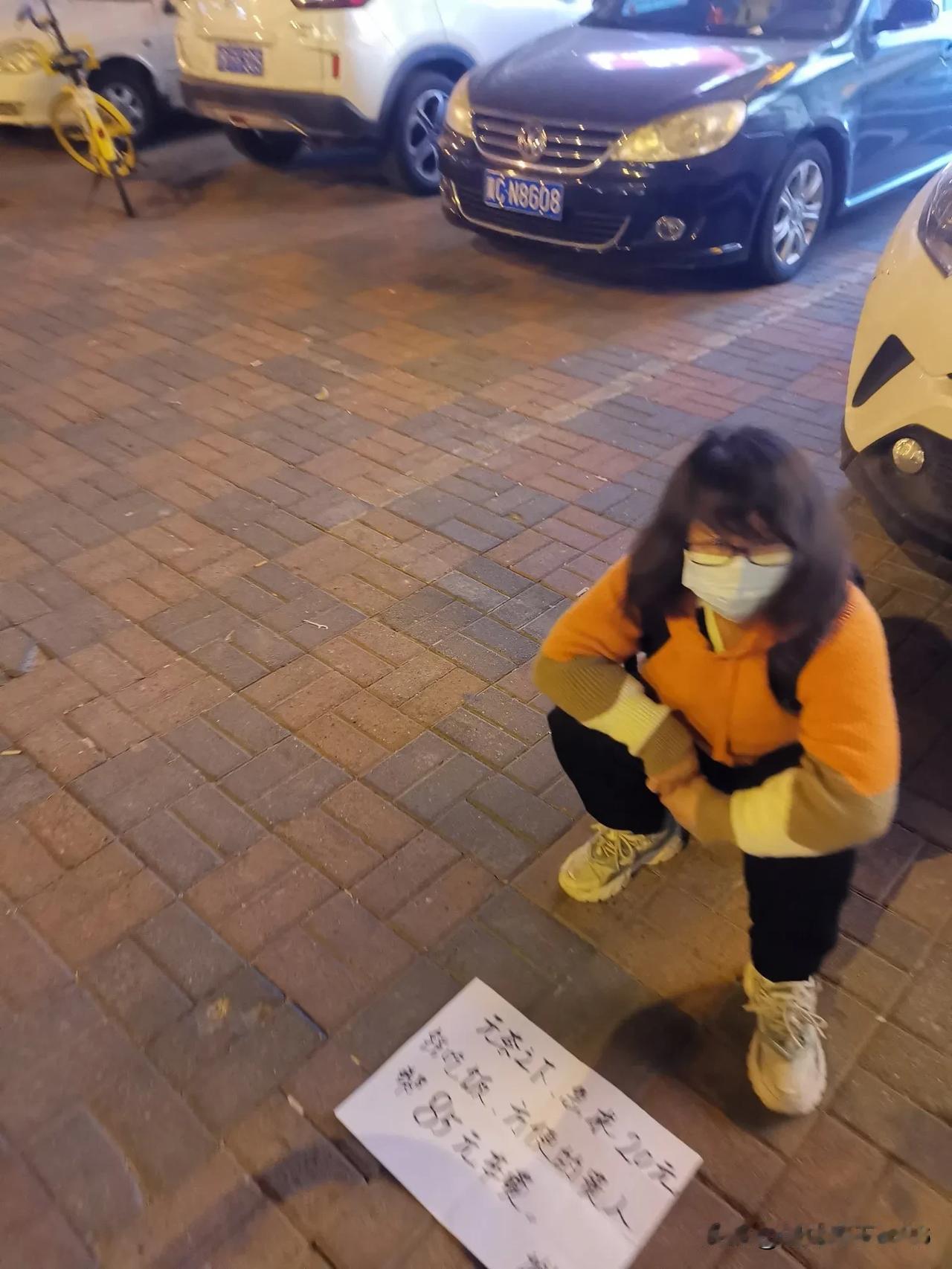 第一次见到这样的情况，有个女士，带着口罩蹲在地上，面前铺着一张白纸，写着“无奈之