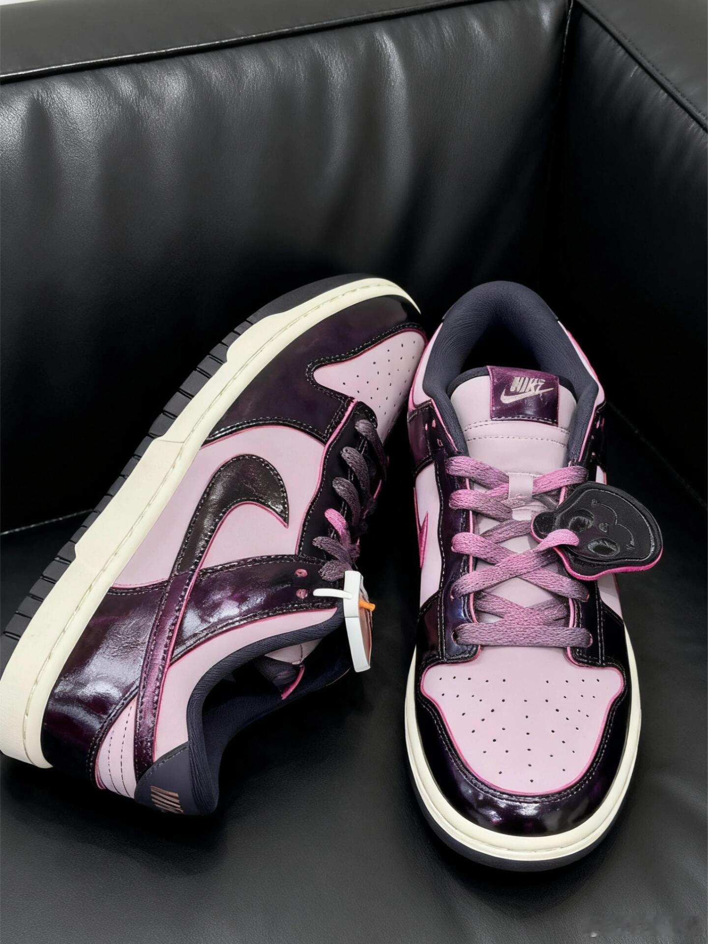 这双Nike Dunk Low以独特的色彩搭配引人注目，鞋面采用深邃的暗紫色漆皮
