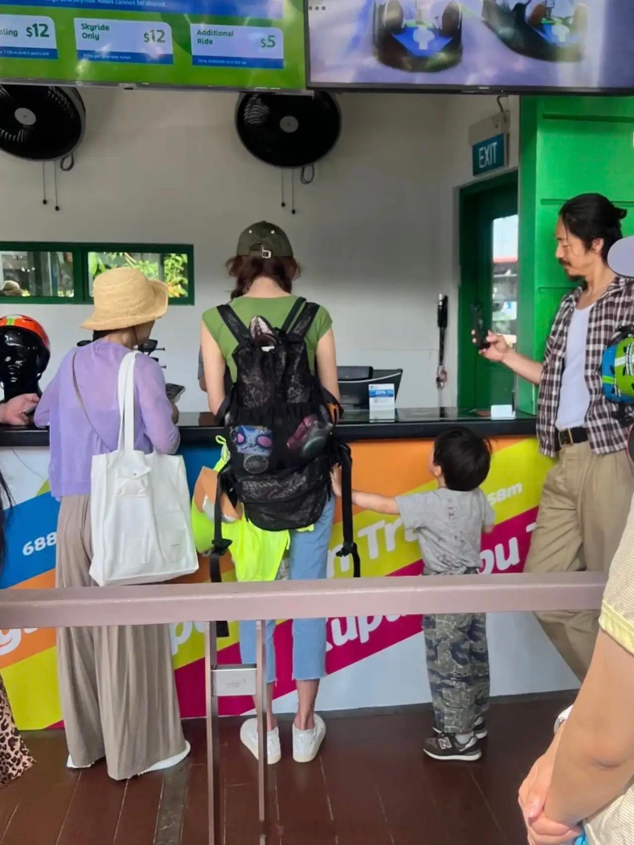 林志玲和老公黑泽良平一起遛娃，林志玲换票，黑泽良平嘴角上扬拍摄老婆。三岁的儿子很