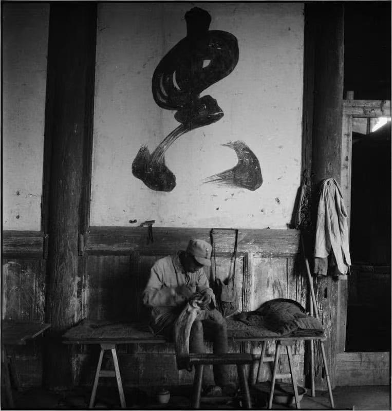 1943年，正在缝补军装的国军士兵，其身后墙壁上的“忠”字很好的诠释了一切！
