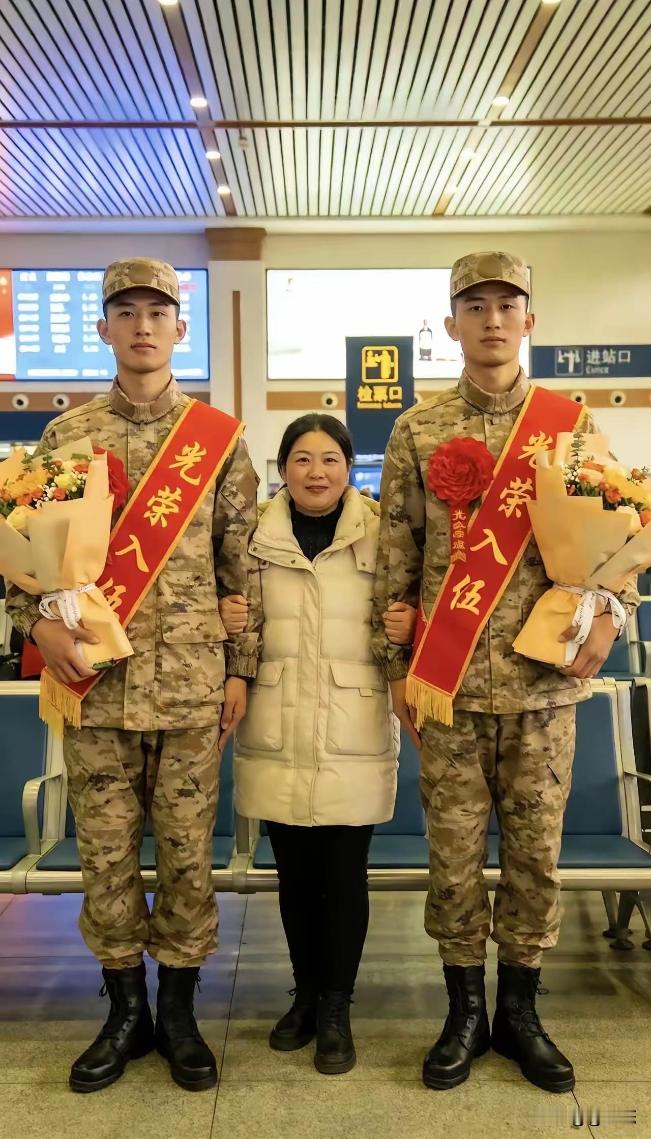 妈妈把两个孩子送去当兵，两个儿子帅气，看起来很有军人的气质。妈妈看起来虽然很小个