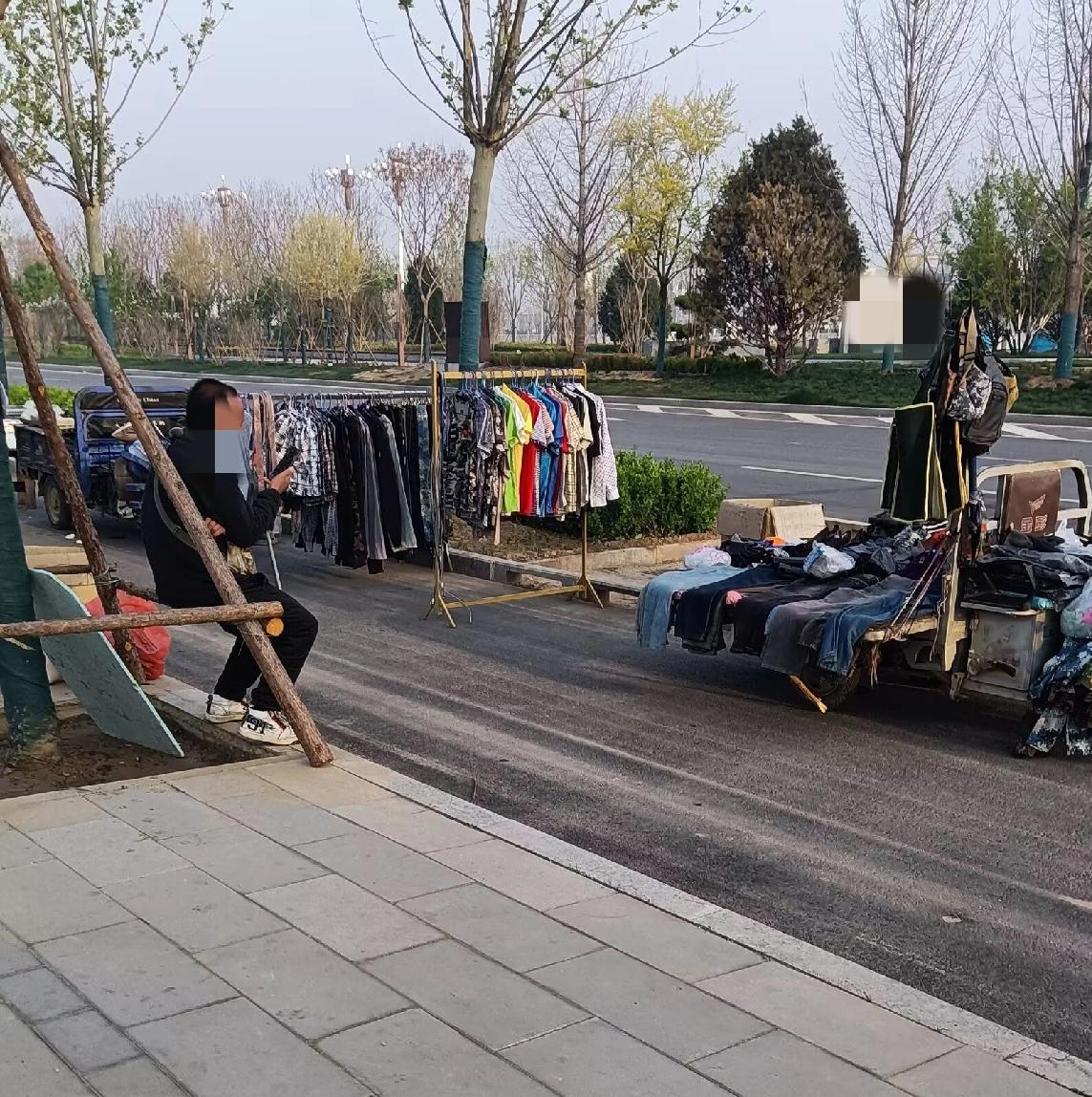 晚上出去散步，看到门口卖衣服的地摊，闲看看，准备买两双袜子。

老师傅在工作门口