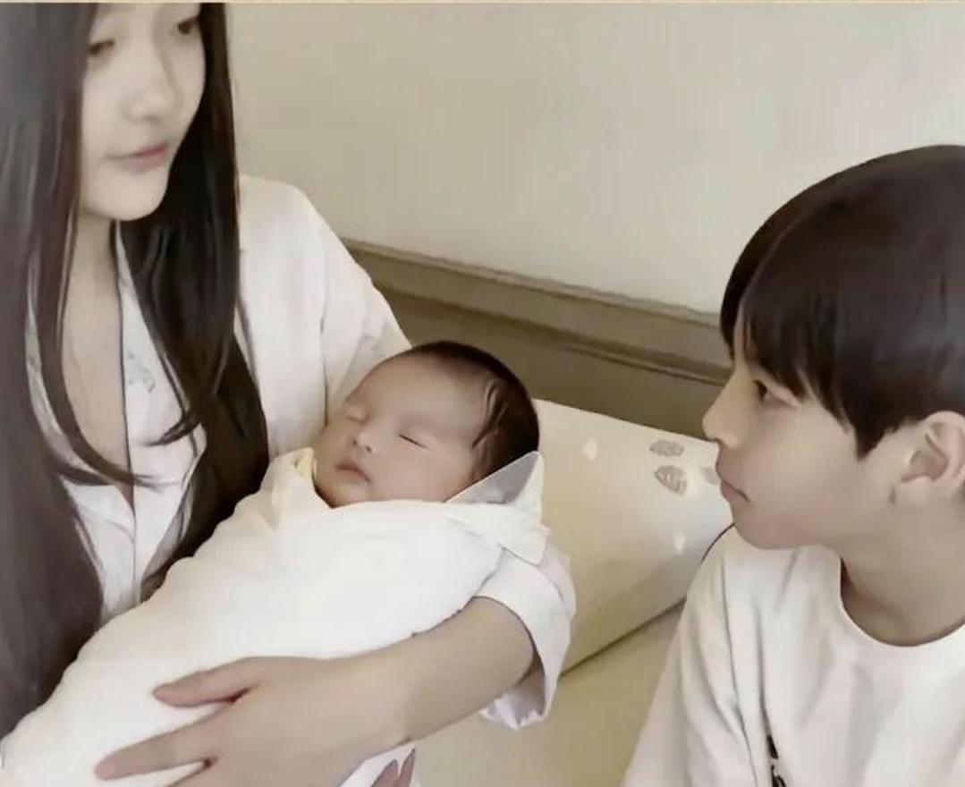 小玥儿抱着刚出生的汪宝，像抱着整个世界。她的眼神专注，也是她要用一生呵护的答案。