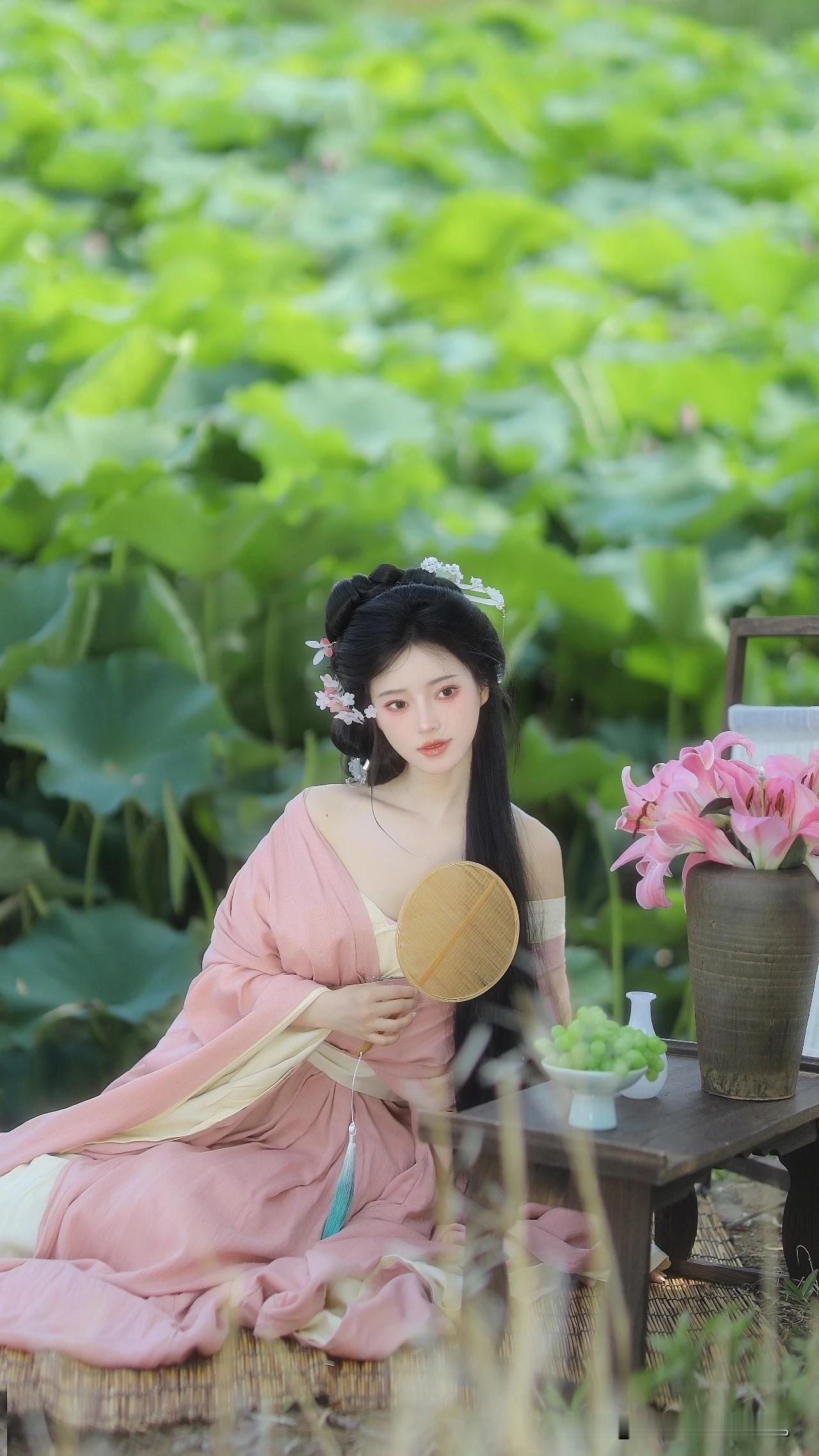 像是从山水画里走出的仙子。
身畔是碧波荡漾的江水，
身后是连绵起伏的青山。
不需