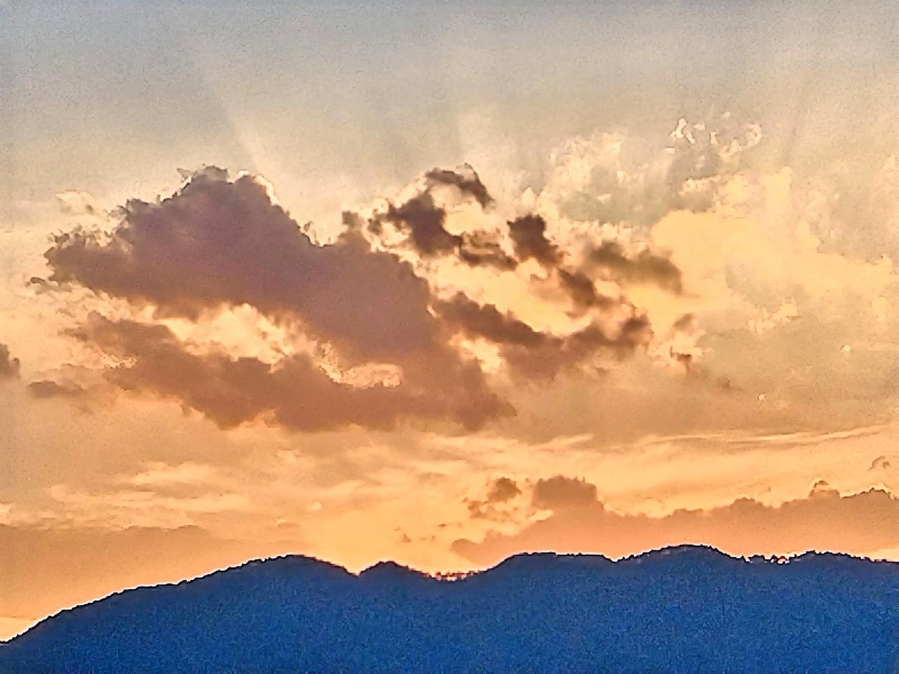 夕阳西下，云海翻涌，山峦连绵，景致美不胜收。彼时，橙红色的夕阳仿若一颗硕大的火球