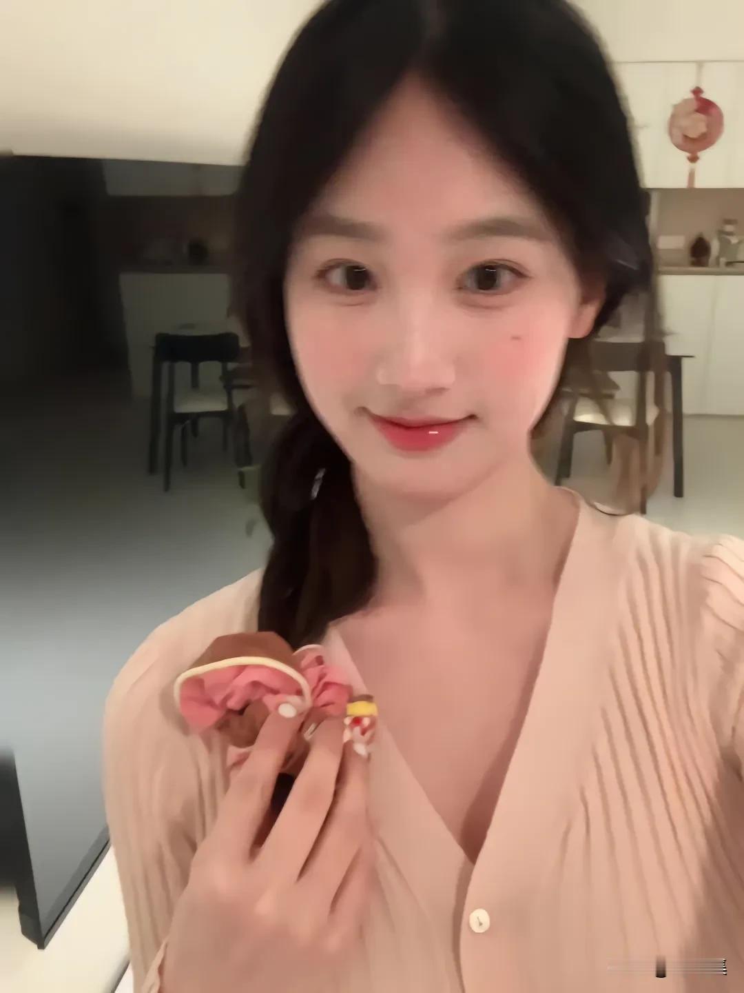 这姑娘手里拿着个可爱小玩偶。