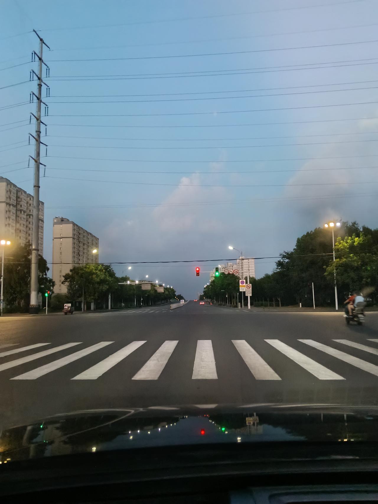 暮色缓缓降临，路灯次第亮起。宽阔马路、林立高楼，车来人往，城市慢慢褪去白日的喧嚣