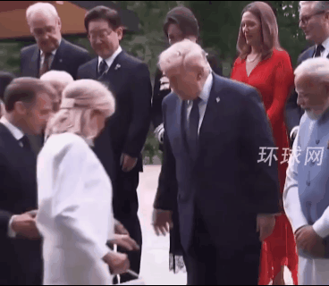 G7峰会大合影，马克龙夫人，穿着高跟鞋上台阶，差一点摔倒，关键时刻她抓住了特朗普