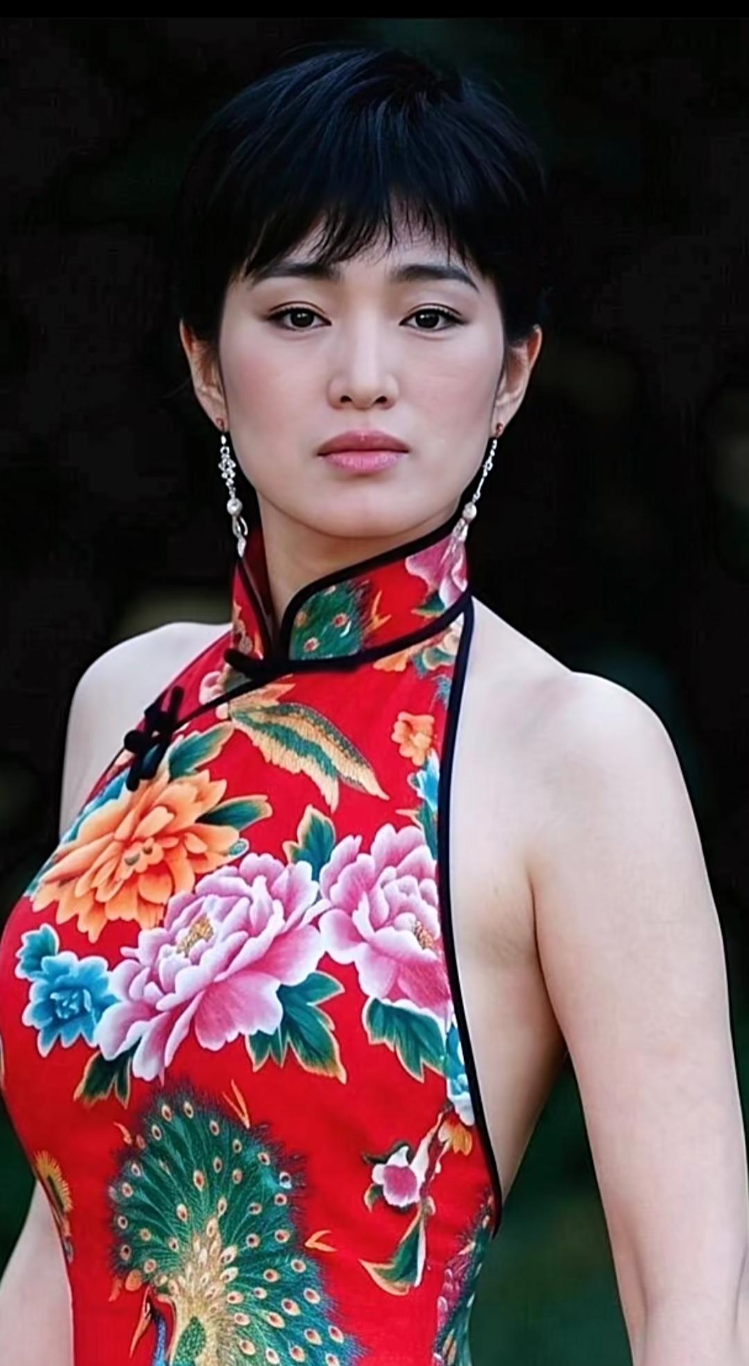 九十年代的经典旧照，
一身红花长裙，像红高粱里走出来的模样，满满的东方韵味。
经
