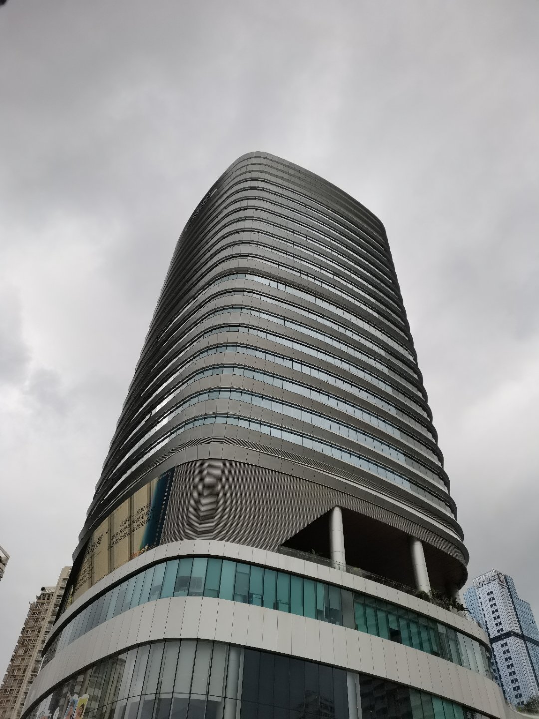 乌云层层压在城市上空，高楼在阴沉天色下静静矗立。闹市里的这片露天野球场，却依旧热