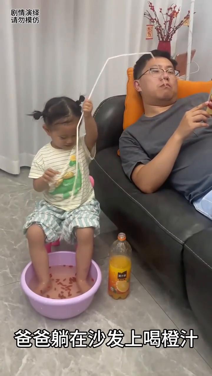 爸爸躺在沙发上喝成汁，然而旁边的女儿正在泡脚，随后她将吸管放盆里，就这样爸爸突然