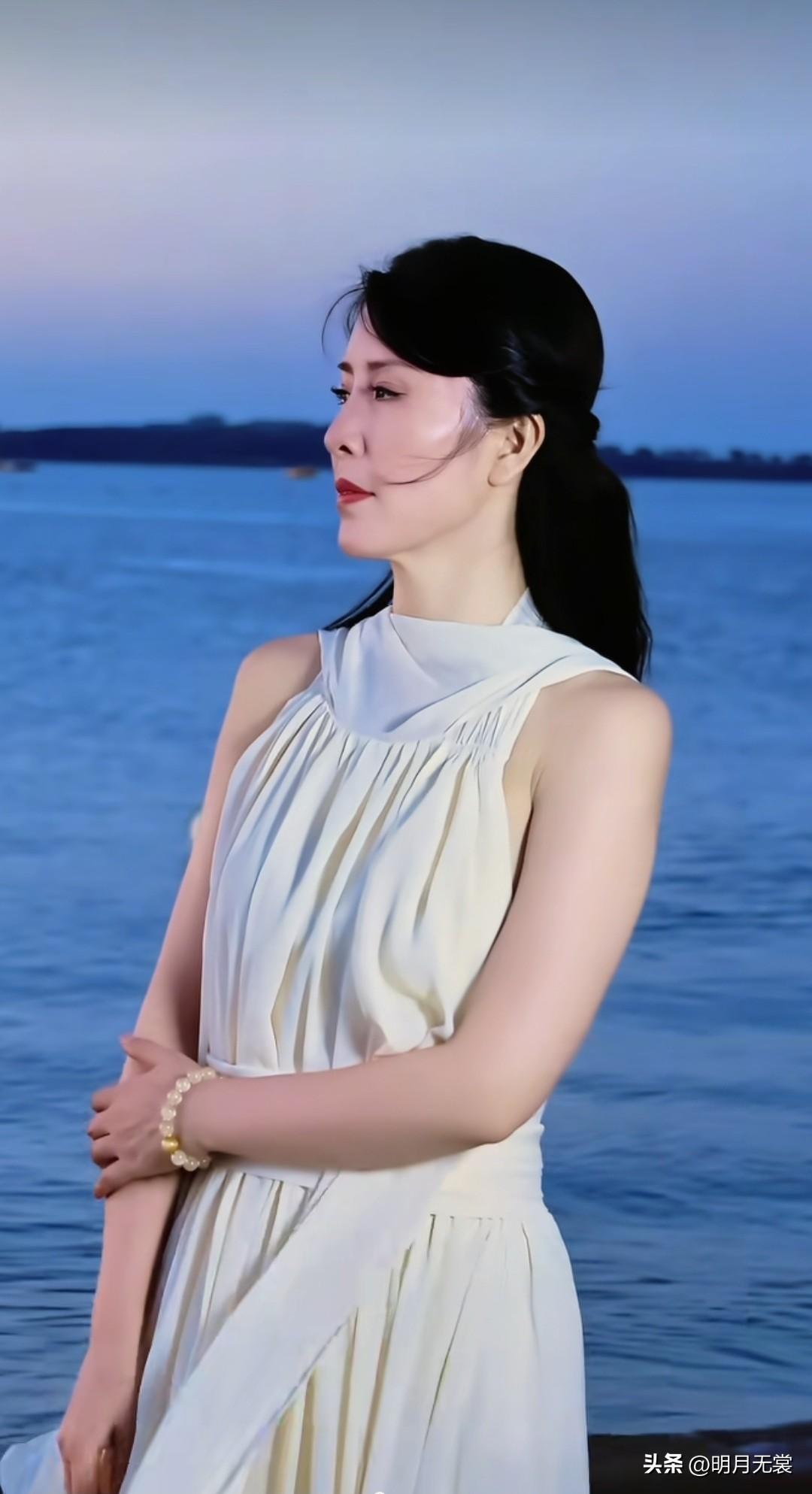 夜风习习，鬓发微乱，江边徘徊的中年美妇。