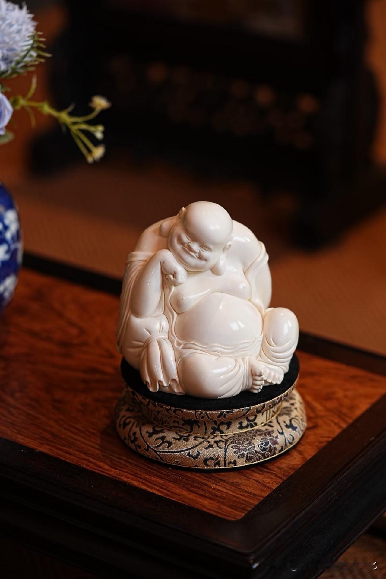 笑意盈盈，自在从容。

5A猛犸雕刻弥勒佛，斜倚布袋，身姿舒展随性。眉眼弯弯，笑