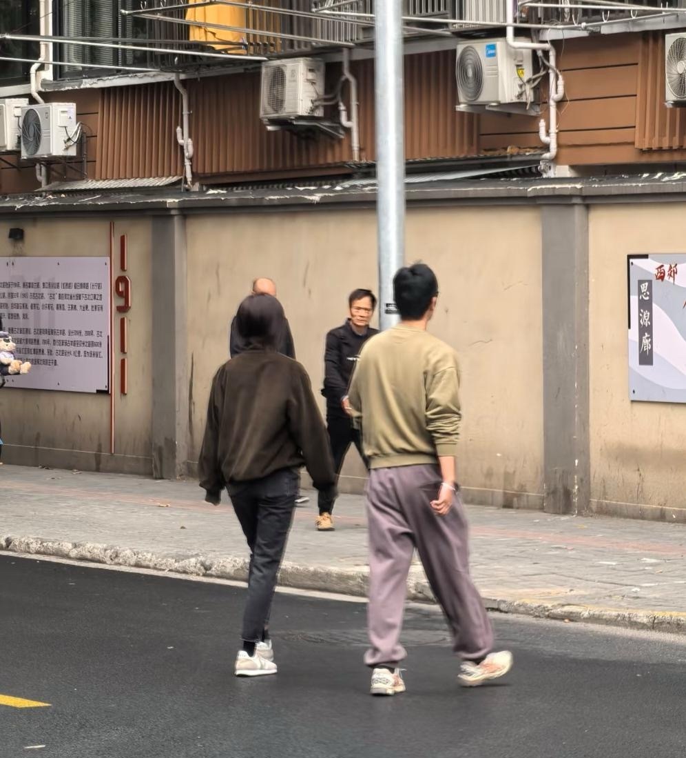 朱亚文和老婆沈佳妮现身上海街头，到学校去接两个女儿放学，夫妻俩穿衣打扮低调，背影