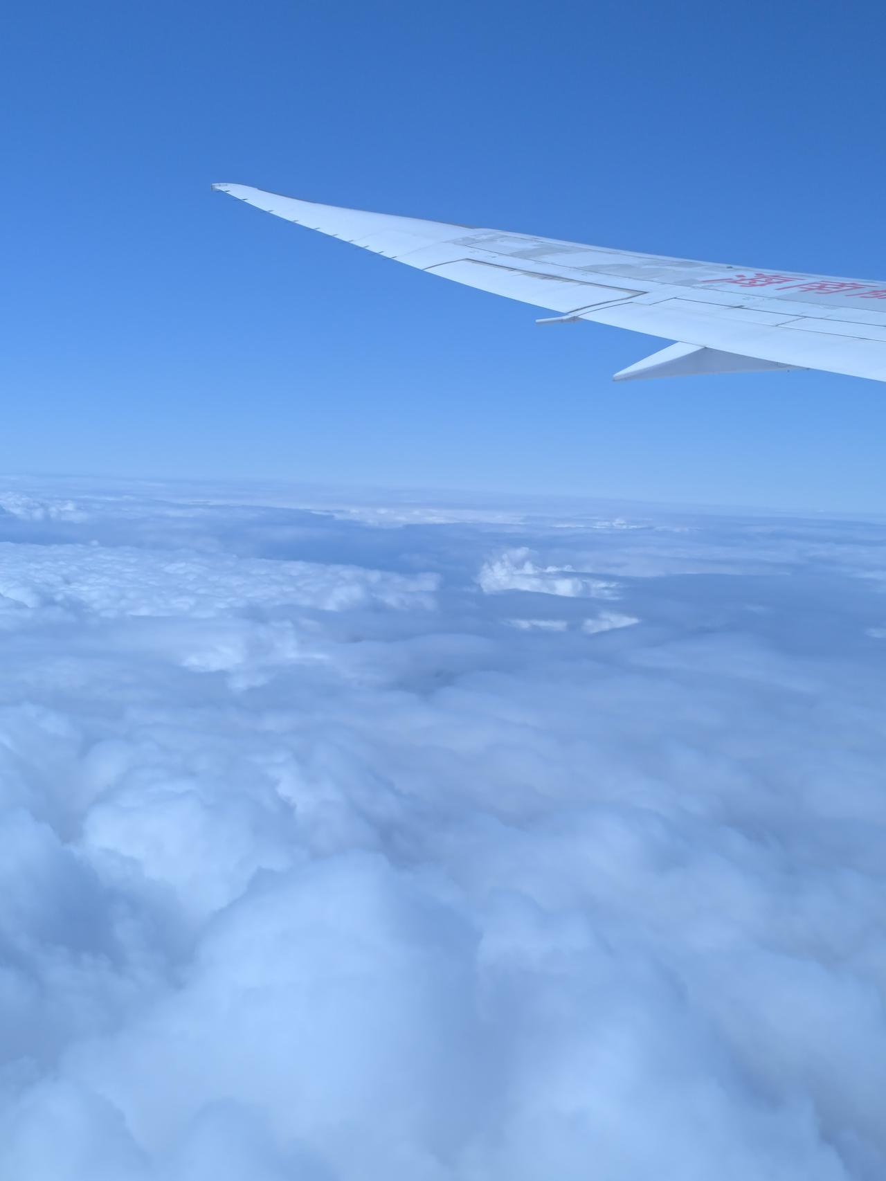 万米高空往下望，云层铺成漫无边际的雪色荒原，连风都冻得放慢脚步，万籁都收了声，只