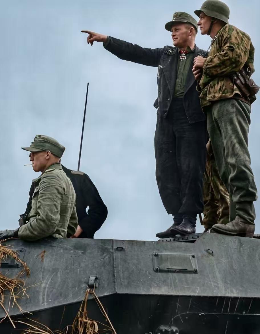 1943年夏，库尔斯克会战期间，德军装甲兵正站立在装甲车辆顶部研究作战方案！
