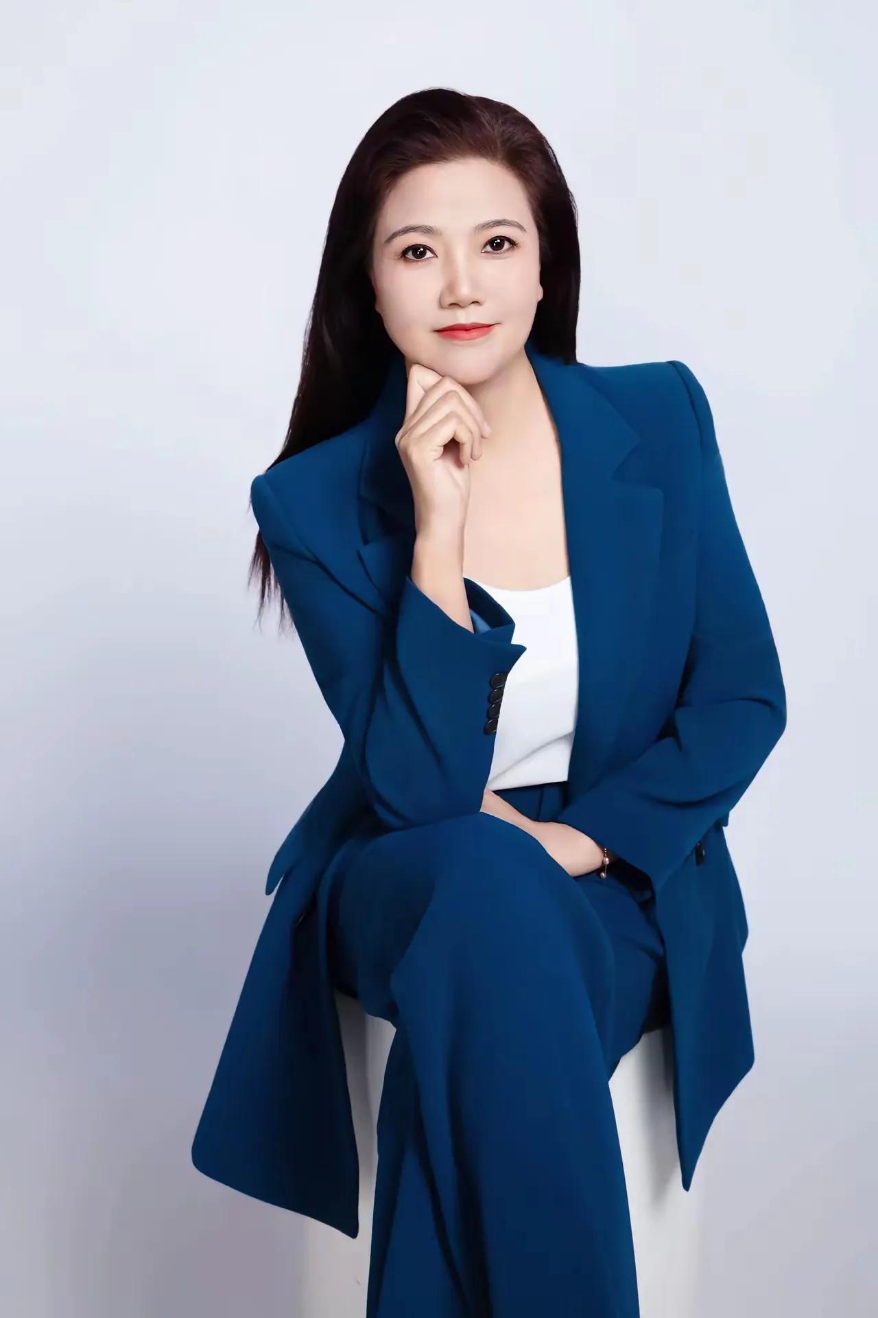 这位职场美女穿着蓝色西装，看起来很有风度。