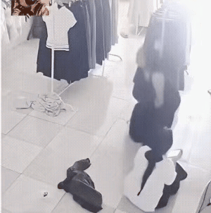 漂亮的服装店服务员在地板上休息，一只老鼠慌不择路霍地从她的下裤口钻进她的裤子里，