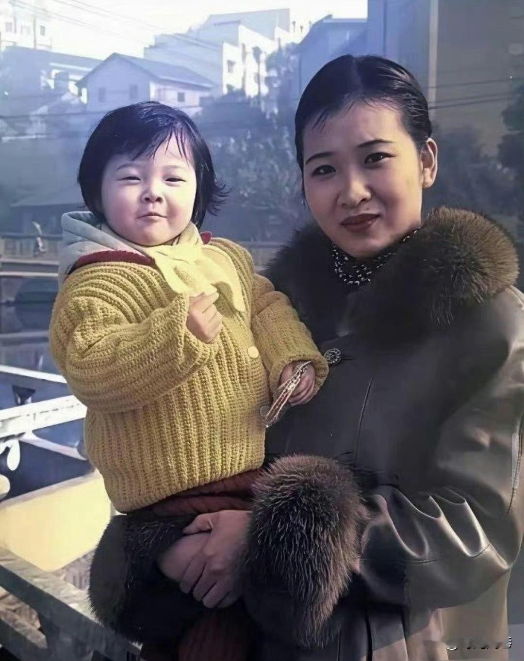 这张富有年代感的旧照片，漂亮妈妈怀抱中的小女孩，看起来胖乎乎的可爱又天真。似乎也