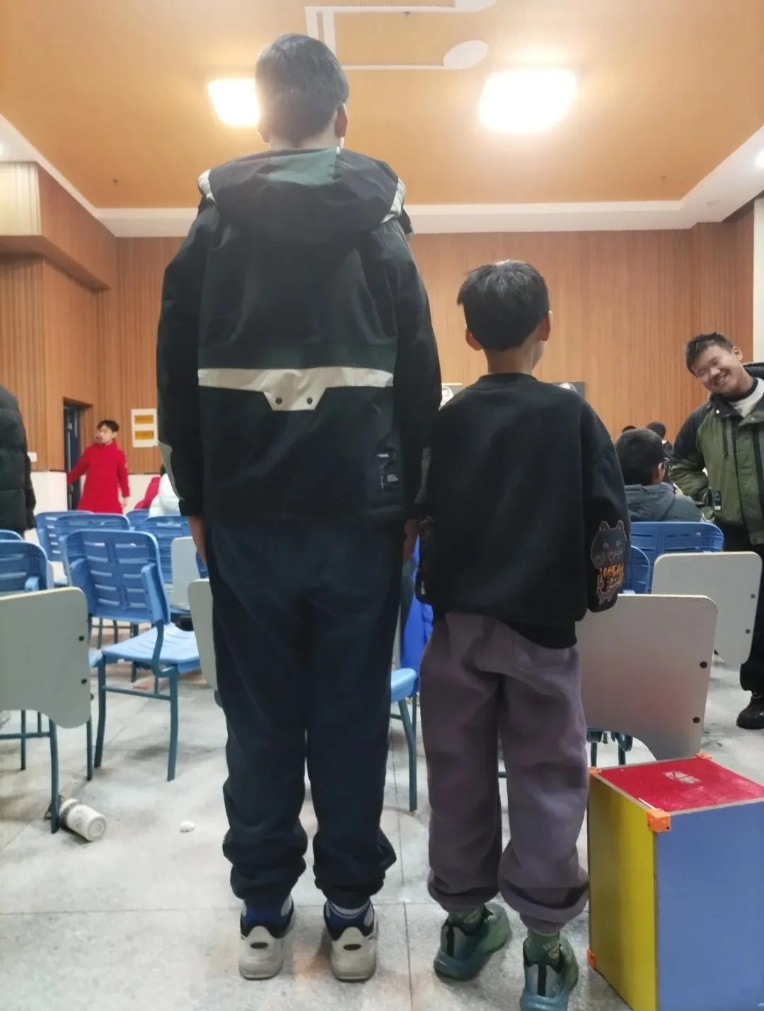 同是七年级学生，一个身高直逼一米九，另一个却矮小得让人不忍询问。两对父母如果相见