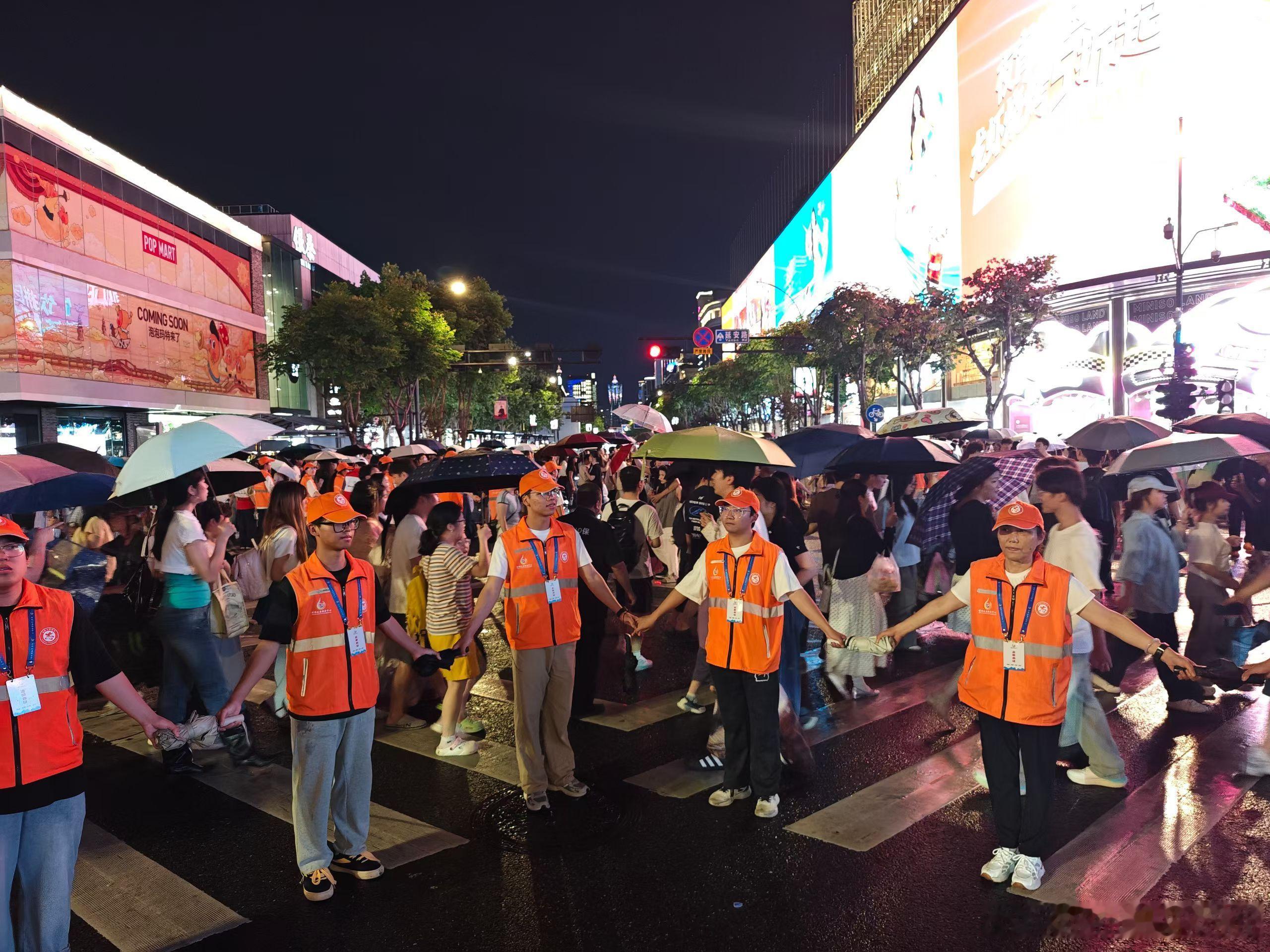 端午阴雨绵绵，湖滨商圈人流如织，晴雨公益“最美人墙”志愿队伍如约值守，配合公安交