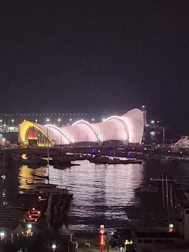 青岛奥帆中心基地夜景美不美，看了就知道！
  夜幕降临，我们站在海信广场的大楼顶