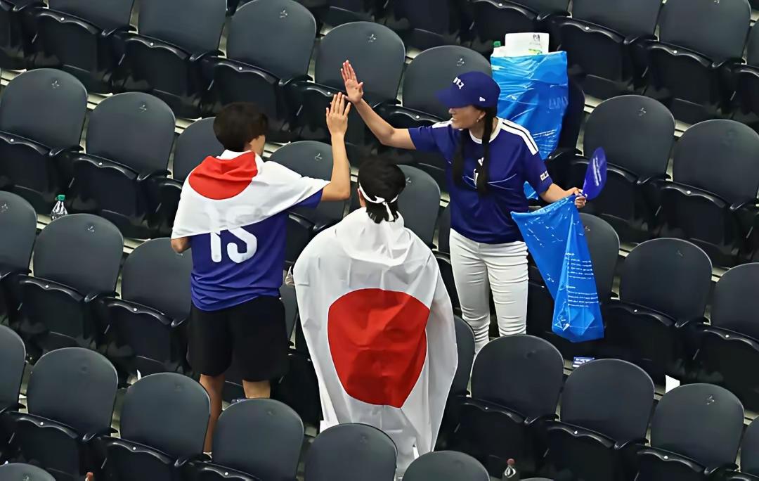 世界杯日本对荷兰终场哨响没几分钟，随队日本球迷没急着撤，掏出自带的大塑料袋，弯腰