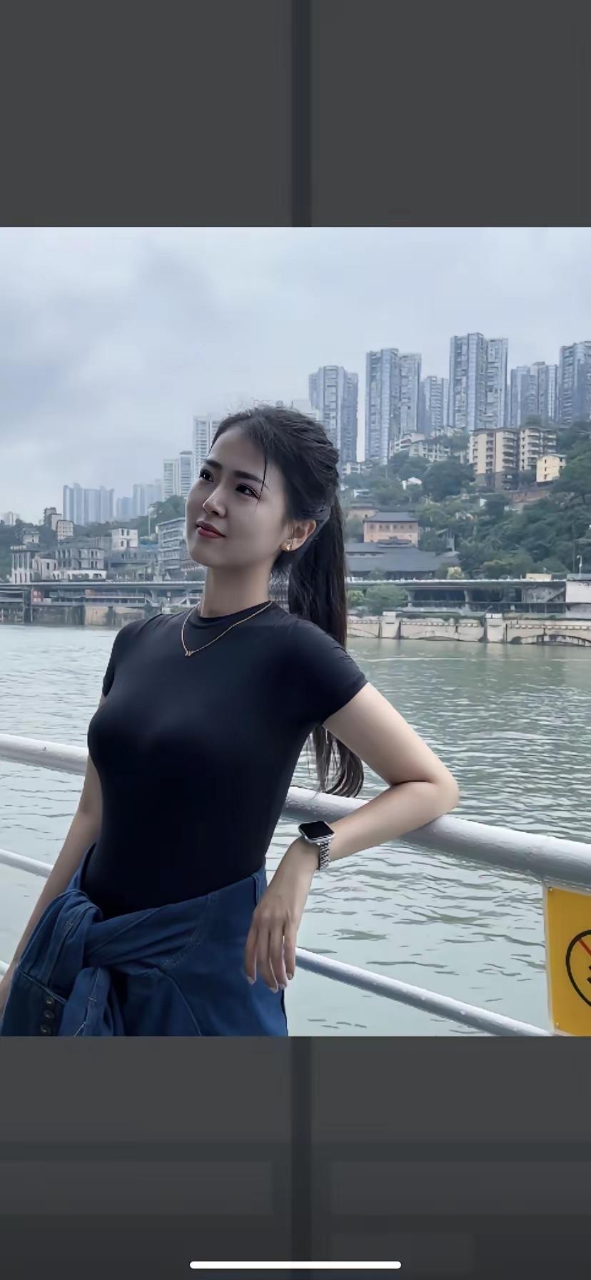 城市河畔的时尚少女，黑衣搭配蓝裙，尽显都市风范。