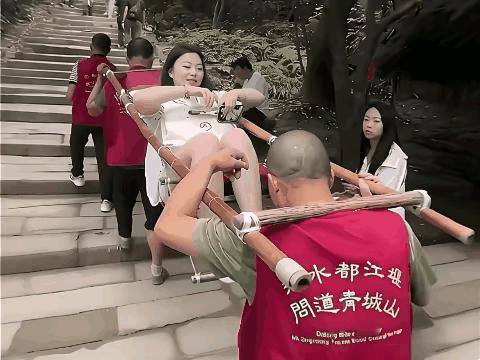 在都江堰青城山的石阶小道上，看到那两位身着红背心的滑竿师傅抬着年轻女游客缓步而上