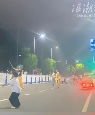 一条通车的市政道路上，多名男女直接占据机动车道，把道路中间隔离护栏当成羽毛球网，