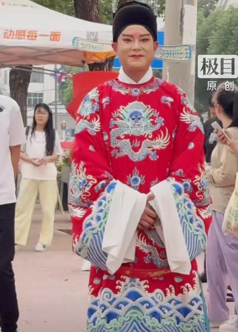 考点外一位穿状元服的爸爸火了，他特意换上一身大红的传统状元服站在考点门口，等着自