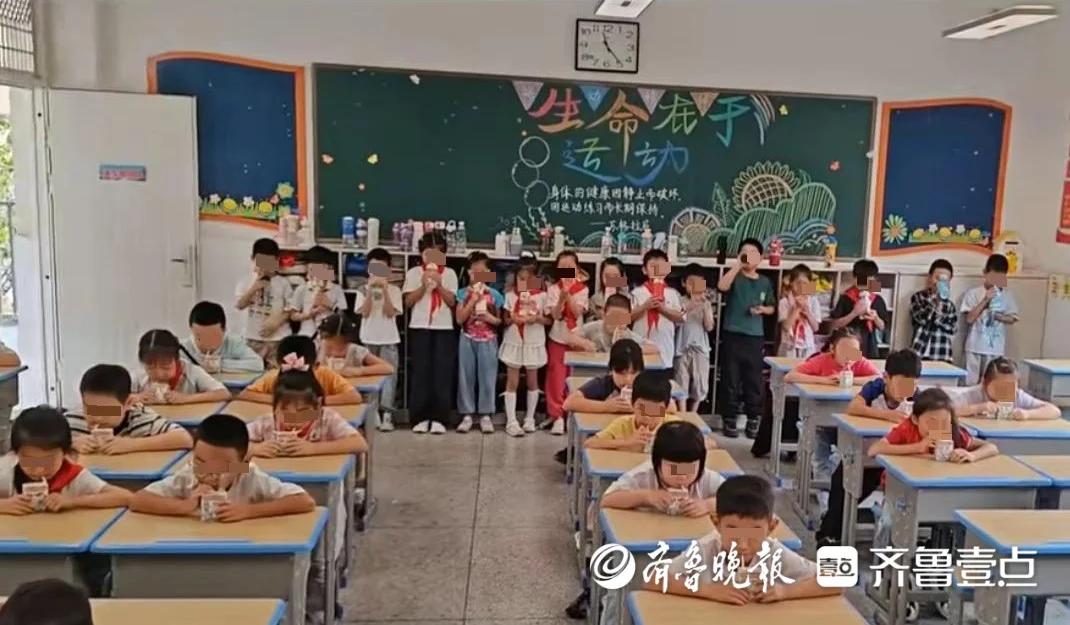 武汉市江夏区某小学。
班主任发了视频在家长群。订了学生奶的孩子坐在座位上喝，没订