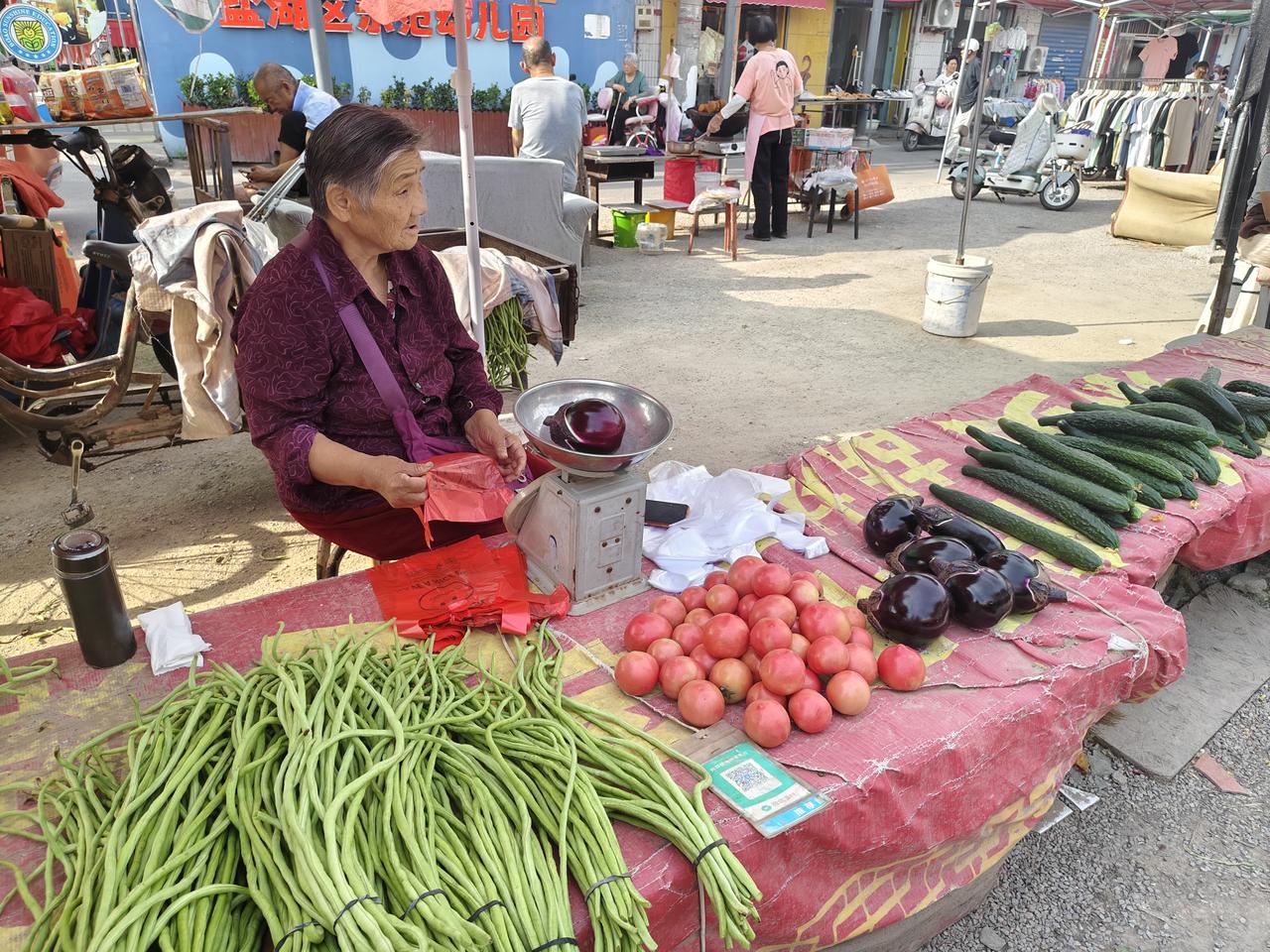 在运城盐湖西街早市的西头，有位卖菜的大婶，她今年80岁左右，每年都是自己种菜自己