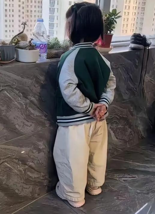 就一个靠墙背影，瞬间看出小朋友满满的“大佬气质”
小家伙背着手静静靠在墙边，小小