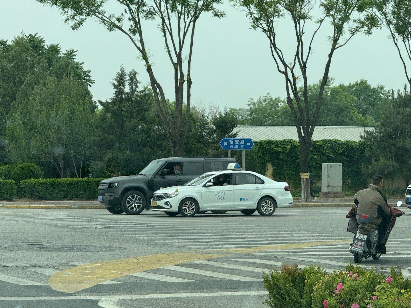家附近有一条开放的公路是可以走驾校车辆的，用于训练和考试。那些教练车全部都是以1
