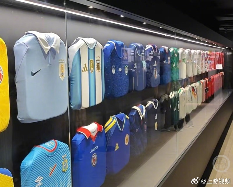 【#大力神杯限时展出球迷排队合影#】#世界杯48队球衣展出横贯整面墙#当地时间7