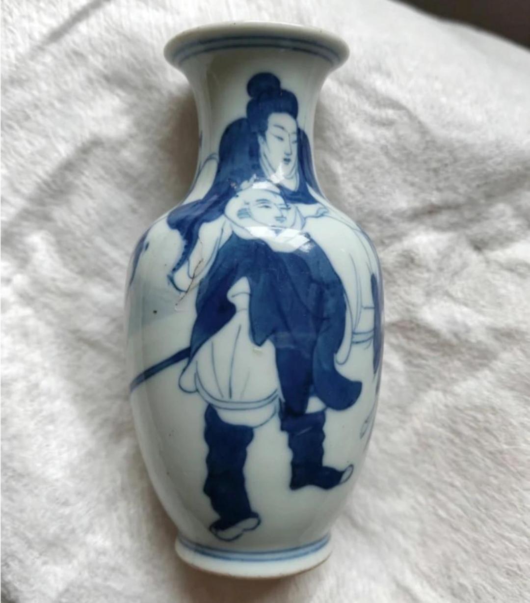一个蓝色花瓶，上面画着两个人。谁知道这是哪个年代的瓷瓶？这是什么瓷，图案真漂亮。