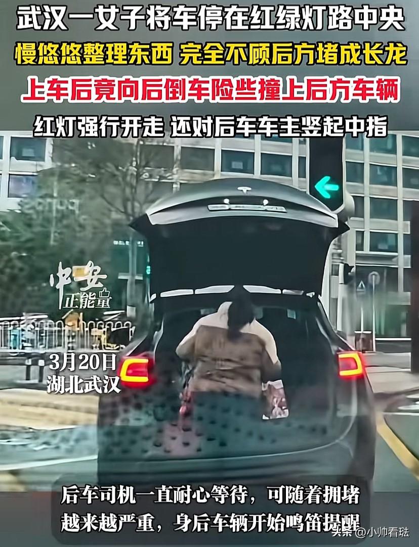 “太嚣张！”湖北武汉，一司机把车停在红绿灯路口，随后下来一女子开始慢悠悠的整理东