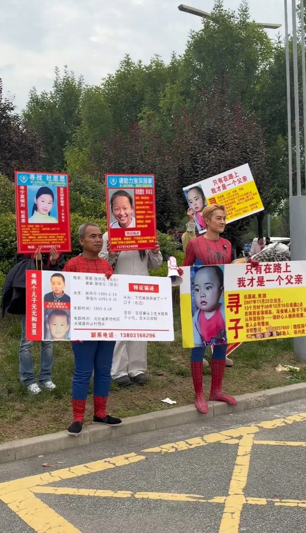 10月2日，陕西西安，知名歌手吴克群扮蜘蛛侠陪寻亲父亲发传单。伍兴虎的儿子伍嘉诚