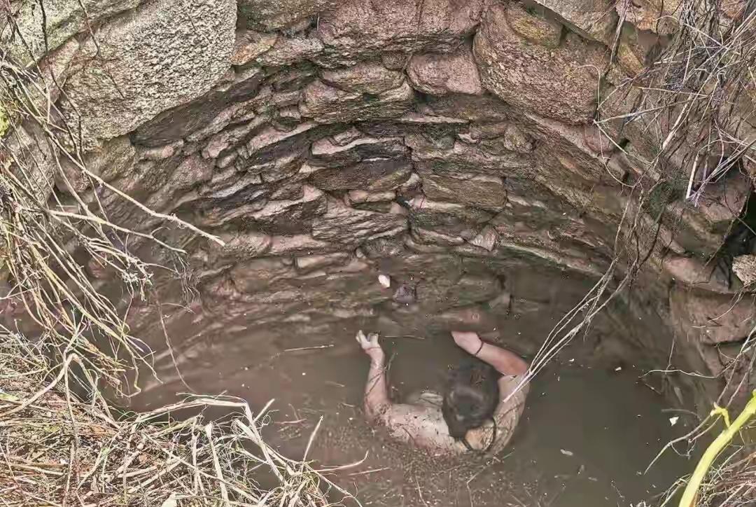 48岁福建覃女士在树林散步的时候，不小心坠进了被杂草覆盖的深水井里，此时才上午9