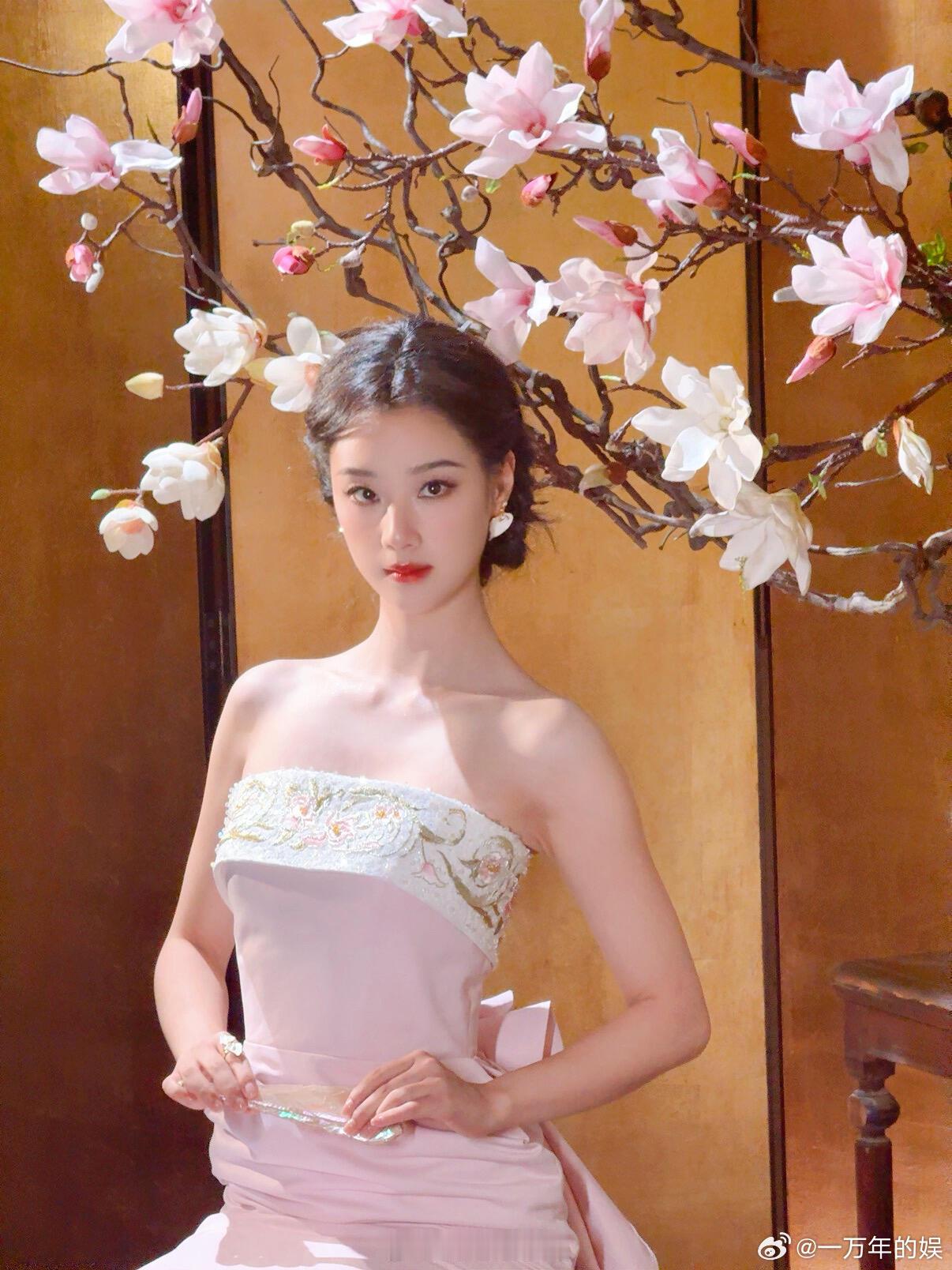王小亿粉瓷美人户外取景搭配粉瓷主题长裙，王小亿和雅致景致相互映衬，衣袂随风缓缓飘